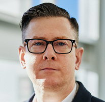 Portrait of Alexander Hughes, executive heading a cryptocurrency trading company